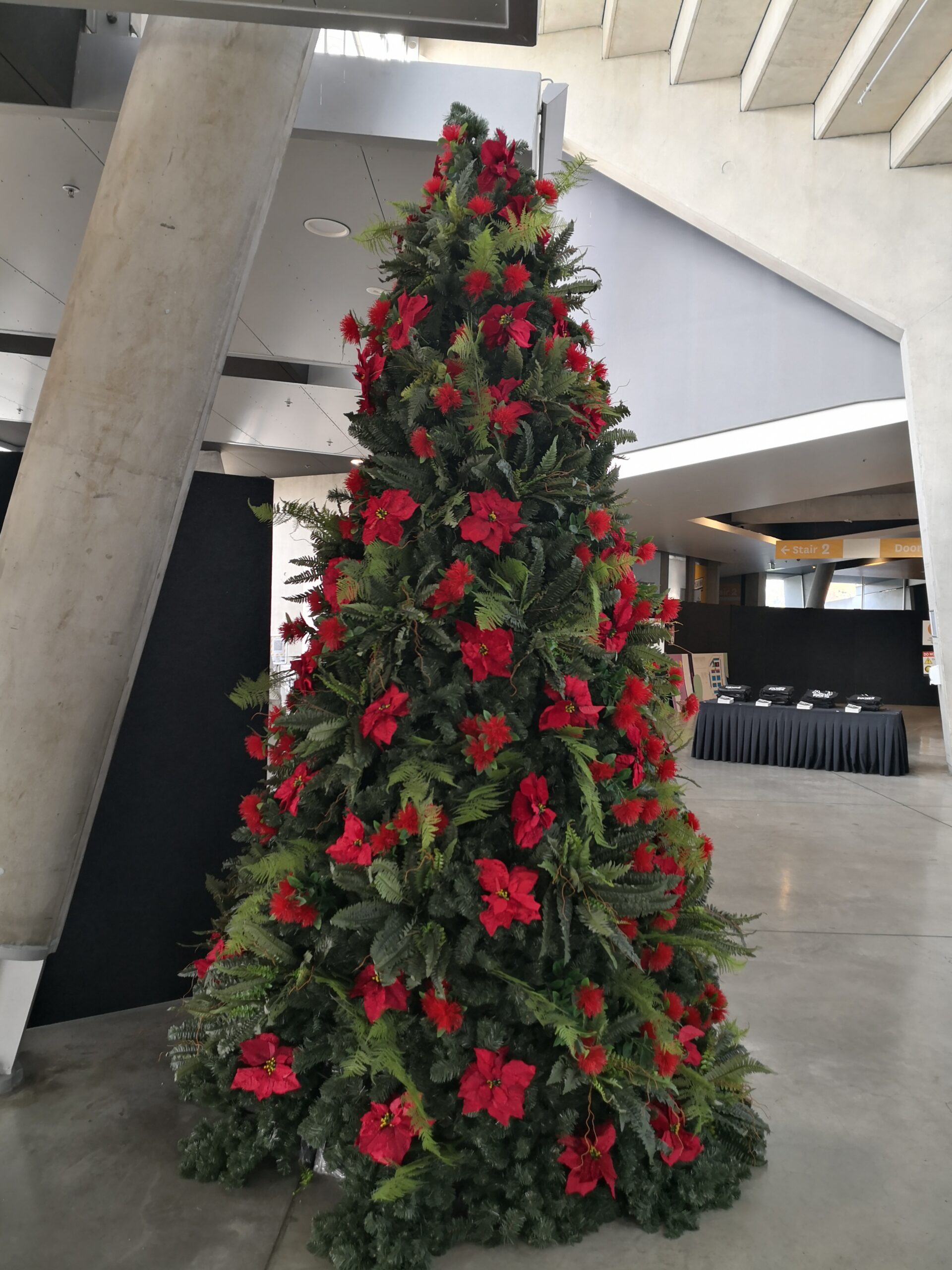 12‘ metal frame green christmas tree with poinsettia & fern decorations 12‘ metal frame green christmas tree with poinsettia & fern decorations
